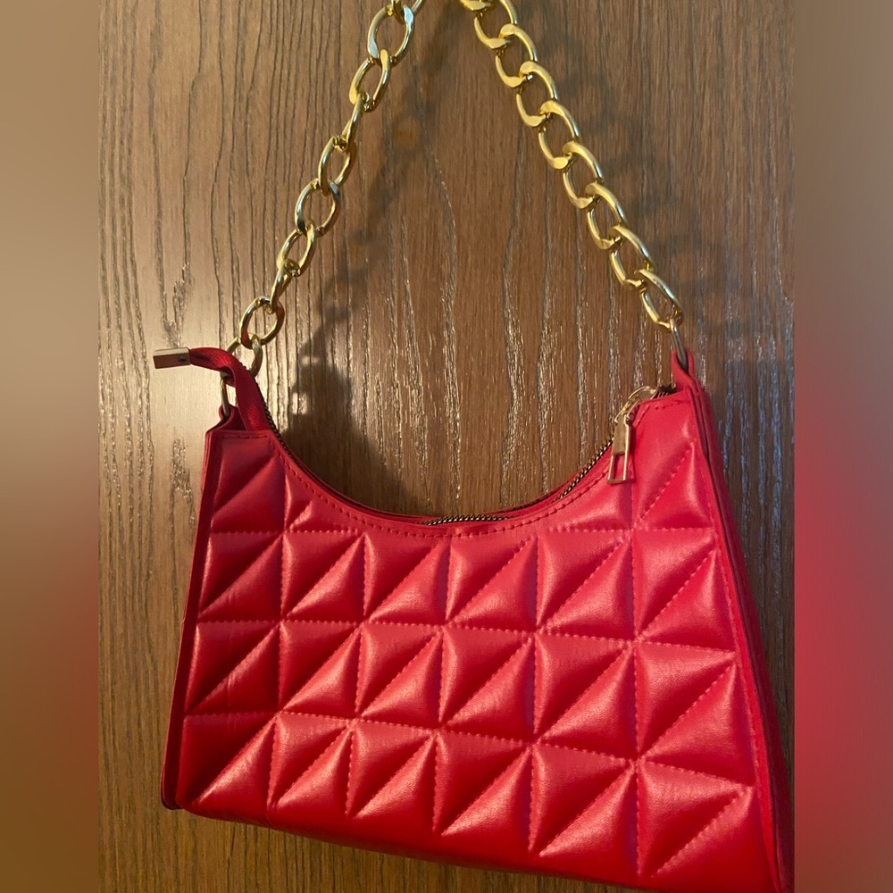 Red purse with gold chain hand